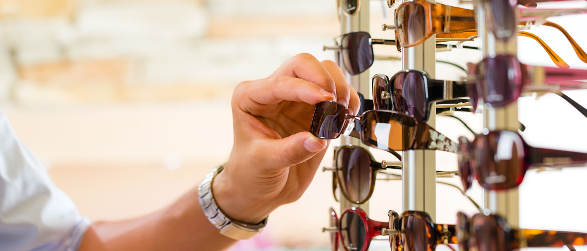 person selecting pair of glasses of a display wall